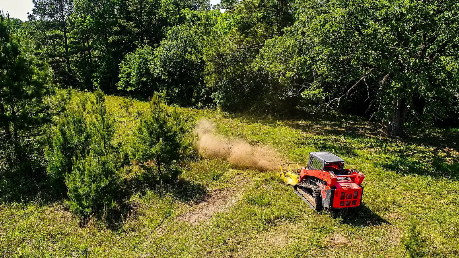 Aerial view of Eberly Earthworks equipment clearing brush on a wooded hillside